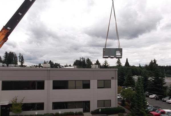 Rooftop unit being carried by a large crane